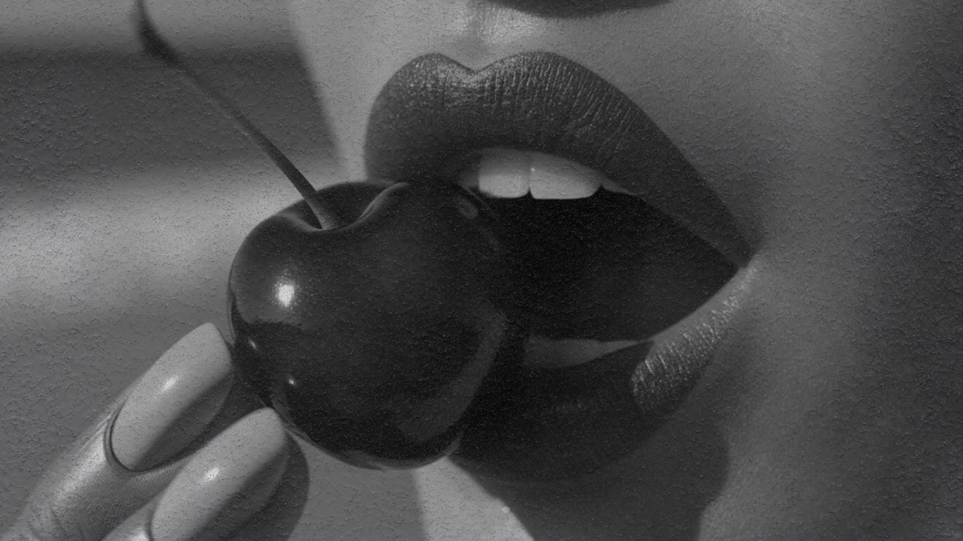 Artistic black and white photo of lips holding a cherry